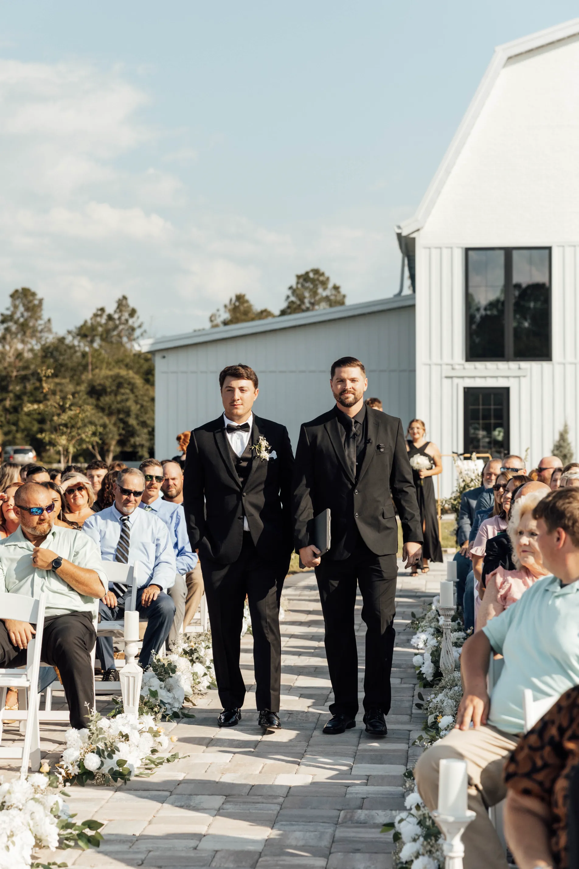 Groom and officiant walking down aisle at North Rail outdoor wedding ceremony