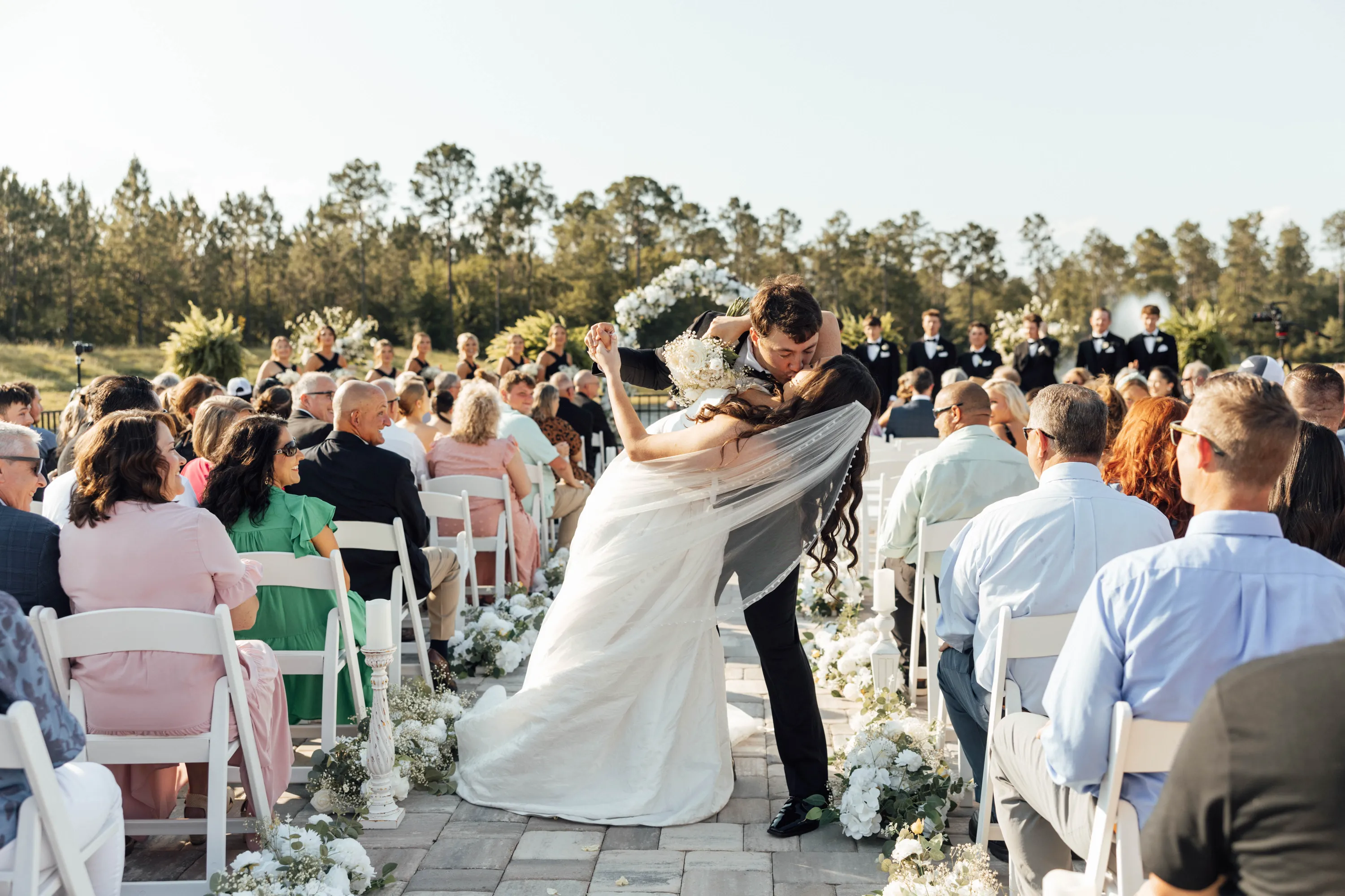 Groom kissing bride at end of wedding ceremony at North Rail lake venue